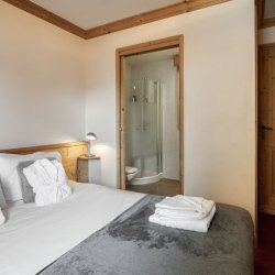 A Double bedroom with ensuite shower room in Catered Chalet Sabot Val in Thorens