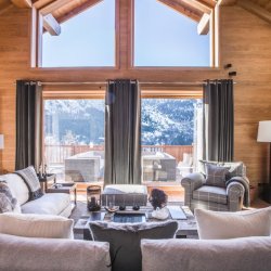 The spacious living room with a fireplace in Chalet Le Grenier Meribel Centre