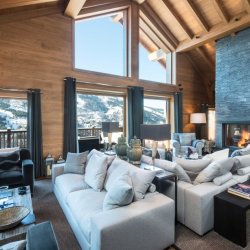 The living area with a fireplace in Chalet Le Grenier Meribel Centre
