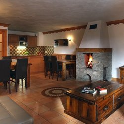 The Living and dining area with fireplace in a Chalet des Neiges Plein Sud apartment Val Thorens