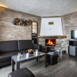 A Living room with fireplace in one of the apartments of Chalet des Neiges Hermine apartments in Val Thorens