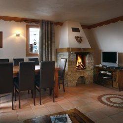 The Dining area and fireplace in a 6 person apartment in Chalet des Neiges Plein Sud Val Thorens